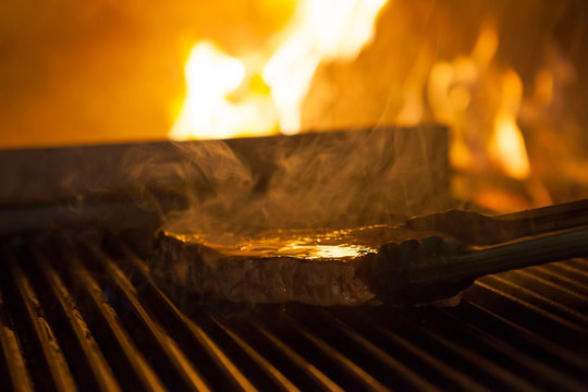 cooking the meat on the grill in the fireplace in the restaurant