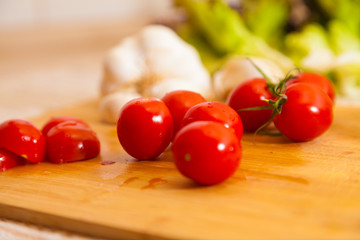 little cocktail tomatoes lies on a board