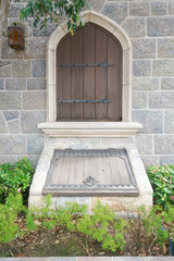 A wooden door in a stone wall with a secret path, medieval door