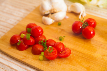 little cocktail tomatoes lies on a board