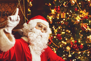 Santa Claus with gifts around Christmas tree