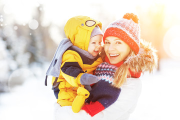 happy family mother and baby is happy snow on winter walk