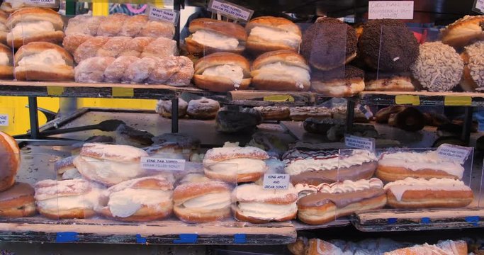 Dispaly of different variety of doughnut and cakes at a food market