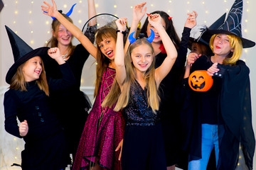 Happy group of teenagers dance in Halloween costumes