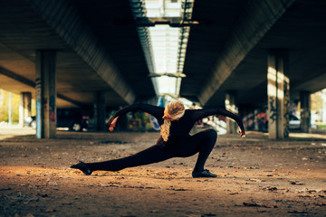 Attractive jazz ballerina dancing under the bridge