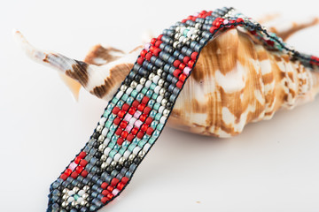 Beadwork. Handmade jewelry. Bead loom bracelet on white background.