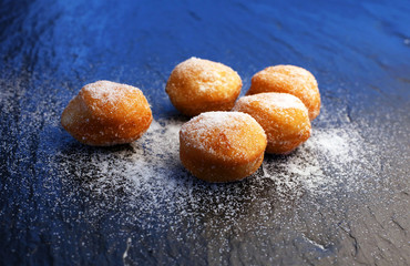 German donuts - berliner with jam and icing sugar in a tray on a dark wooden background.