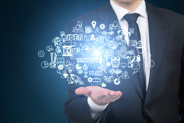 Businessman holding business icons in his palm