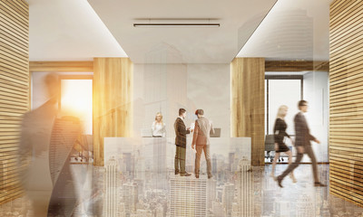 Rear view of business people in office with two receptionists an