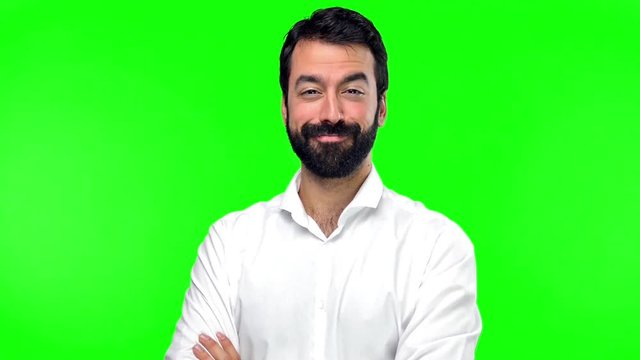 Handsome man with his arms crossed on green screen chroma key