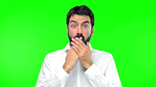 Handsome man making surprise gesture on green screen chroma key