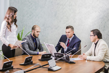 business people having a meeting conference talking about future success of the company. modern city office 

interior, group of four business man working on laptop at meeting together in room