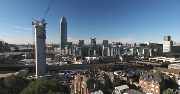 Aerial ascending view of contemporary riverside development and skyscrapers by the river Thames in London