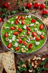 Vegetables Green Omelette with tomatoes, kale, greek cheese, olives, nuts, toast on wooden background. concept healthy food