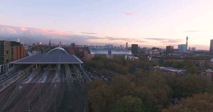 Aerial ascending view of King's Cross station at sunset with the skyline of central London in the background