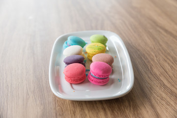 Dessert Macaroon placed in a dish with a wooden background.