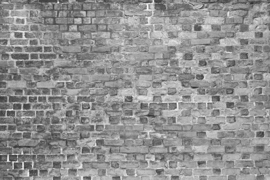 Grey wall with broken bricks.