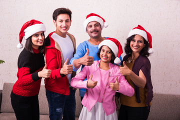 family, happiness, generation, holidays and people concept - happy indian family in santa helper...