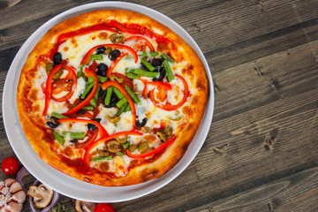 fast food. vegetarian pizza with vegetables on a wooden table with copy space. top view