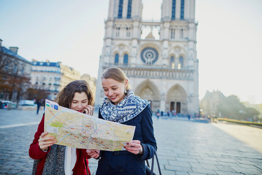 Two young girls taking selfie near Notre-Dame in Paris