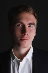 portrait of a young man with cunning eyes in white shirt