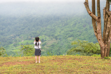 Asian girl with a camera in the garden.