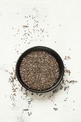 chia grains in a black bowl on a white table