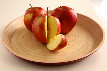 Fototapeta na wymiar Red apples on a wooden plate the table