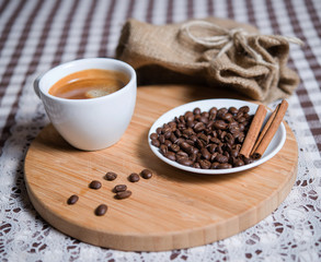 cup of coffee and coffee beans on a plate