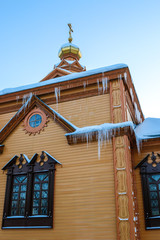Wooden church in Russia. Frost. Temple decorated with icicles and snow drifts.