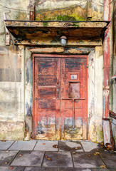 Entrance door into ruined vintage house.