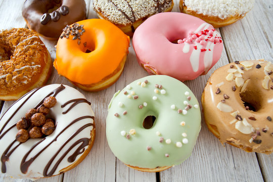 variety of doughnuts on wooden surface