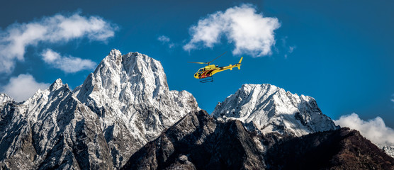 Elicottero in volo tra le montagne 