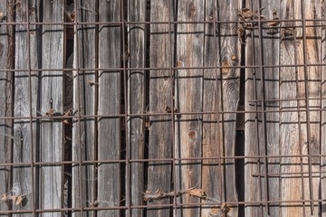 Holzwand mit Eisengitter