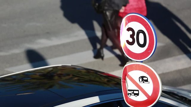 Speed Restriction Road Sign And Pedestrian Crossing The Street