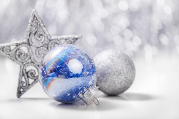 Silver and Blue Christmas ornaments on glitter bokeh background with space for text. Xmas and Happy New Year theme