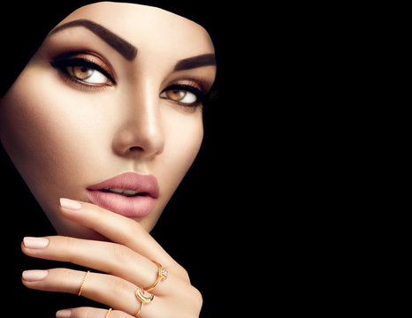 Beautiful muslim woman face portrait. Beauty arabian woman with perfect makeup and manicure isolated on black background