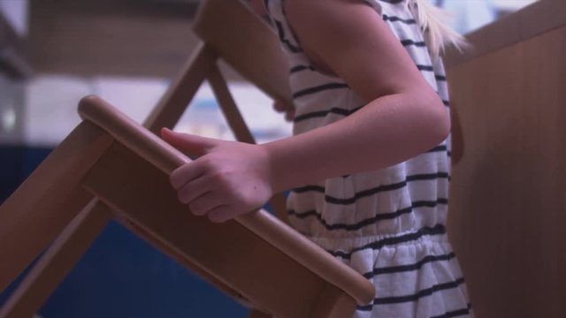 FOLLOW Adorable child bringing wooden chair to the kitchen to cook together with her mother. 4K UHD RAW edited footage
