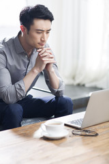 Young man working with laptop in office