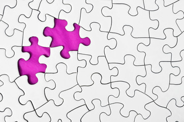 A top view image of a white jigsaw puzzle with a missing puzzle piece.