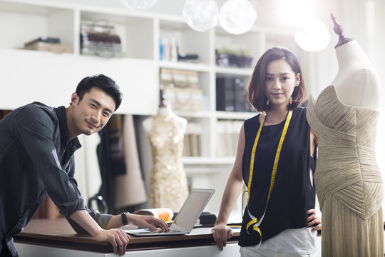 Portrait of two young fashion designers working in fashion boutique