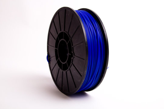 Side view of standing blue 3D printer filament spool