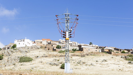 electricity pylon and a view of Magacela town, Badajoz, Spain