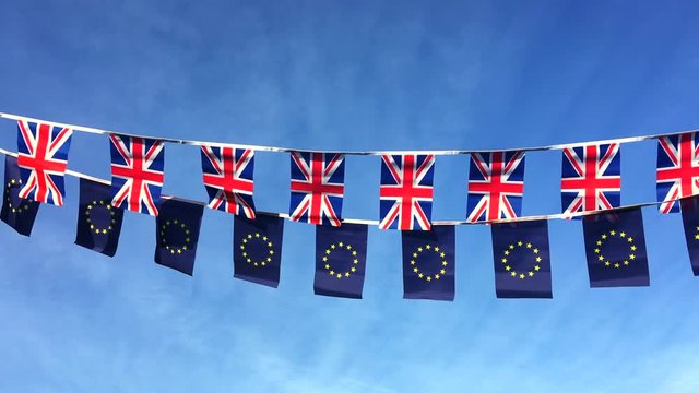 European Union and British Union Jack flag bunting flying in bright blue sky in a statement of the Brexit EU referendum