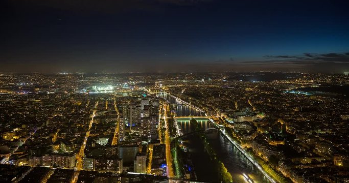 Paris, France - southwest-view over illuminated Paris with Seine River by night - Timelapse with zoom out