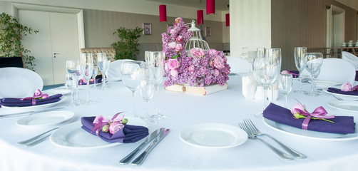 Festive table setting in the restaurant with flowers. Wedding decor.