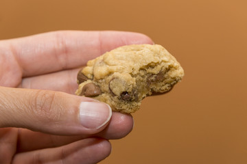 Closeup of inside of soft moist chocolate chip cookie held in wo