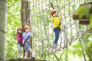 Happy children playing in tree top adventure park