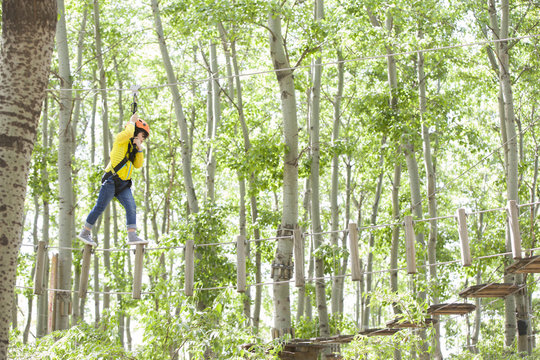 Little boy playing in tree top adventure park