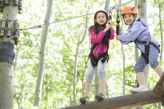 Little girls playing in tree top adventure park